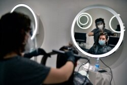 Andrea, 29 years old, is attended by hairstylist Laura Naturana in a salon in Pamplona, northern Spain, May 4, 2020.