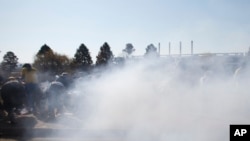 Protesters run away after police fired two warning shots to clear the street from a demonstration against the visit of United States President Barack Obama to the university building in Soweto, South Africa, June 29, 2013.