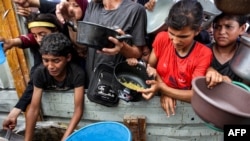 Children gather with pots to receive food from a kitchen at the Jabalia camp for Palestinian refugees in the northern Gaza Strip on June 13, 2024. Australia announced an additional $6.6 million in food aid for Gaza on Wednesday.