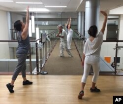 FILE - Violinist Anthony Hyatt leads dancers through MedStar Georgetown University Hospital in Washington, Oct. 11, 2017.