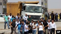 Paramedics and other people carry away a body after an explosion at a police station near the city of Diyarbakir, southeastern Turkey, Monday, Aug. 15, 2016.