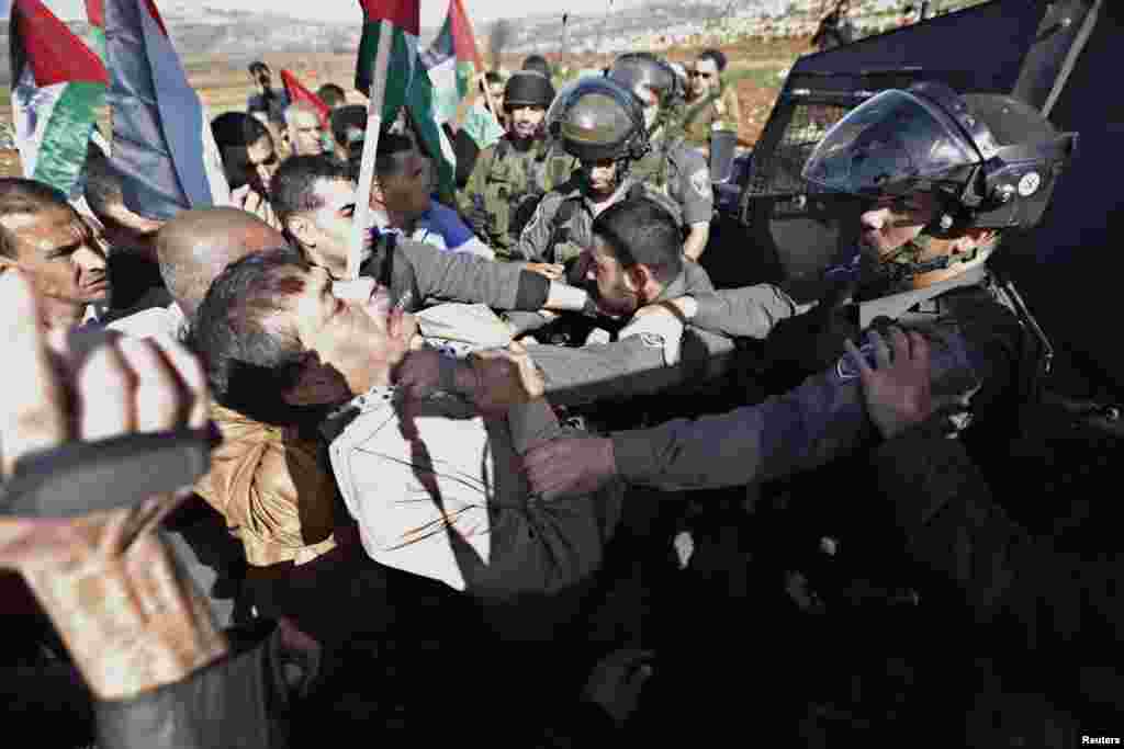 Palestinian Minister Ziad Abu Ein (left) scuffles with an Israeli border policeman near the West Bank city of Ramallah, Dec. 10, 2014.