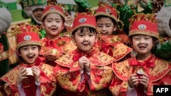 Children wearing traditional costumes pose during preparations for Chinese lunar new year celebrations in Hong Kong on February 17, 2015.