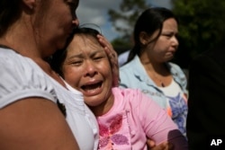 May Thein, center, the mother of Myanmar migrant Win Zaw Htun, is overcome with emotion after his guilty verdict at court in Koh Samui, Thailand, Thursday, Dec. 24, 2015.