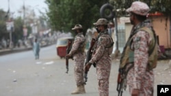 Security personnel stand guard after the government announced to lockdown the city concerns over the spread of the coronavirus, Karachi, Pakistan, March 23, 2020.