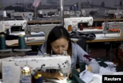 FILE - A woman works in a garment factory in Beijing's Qingyundian industrial zone, Oct. 19, 2015.