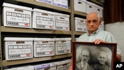 Jack Goins poses with a photo dated to have been taken in 1898 of his step-great-great grandfather George Washington Goins, who died in 1917, left, and great-great grandmother, Susan Minor-Goins who died in 1913 at the Hawkins County Archives Project buil