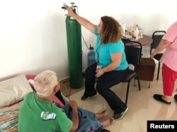Dr. Lourdes Marrero shows a patient how to use an oxygen tank if the generator fails at a public shelter in Orocovis, Puerto Rico, Oct. 3, 2017.