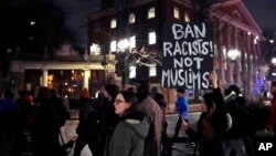 Several hundred people march past the gates of Harvard Yard at Harvard University while protesting the travel ban in Cambridge, Mass., March 7, 2017. 