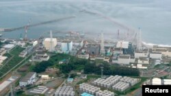 An aerial view shows Tokyo Electric Power Co. (TEPCO)'s tsunami-crippled Fukushima Daiichi nuclear power plant and its contaminated water storage tanks (bottom) in Fukushima, in this photo taken by Kyodo August 20, 2013. Japan's nuclear watchdog said on W
