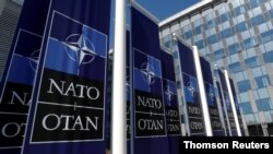 FILE - Banners displaying the NATO logo are placed at the entrance of new NATO headquarters during the move to the new building.