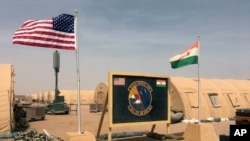 FILE - US and Niger flags flutter side by side at a base camp supporting the construction of Niger Air Base 201 in Agadez, Niger, April 16, 2018. Niger's ruling junta last month told the U.S. to withdraw its nearly 1,000 military personnel from the country.