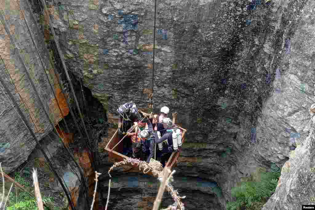 Divers use a pulley to enter a coal mine to rescue trapped miners in Umrangso, a remote area in the northeastern state of Assam, India.