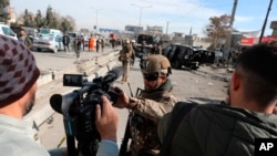 Polisi keamanan Afghanistan memblokir seorang jurnalis TV dari syuting di lokasi serangan bom di Kabul, Afghanistan, 10 Februari 2021. (Foto: AP)