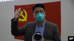 Dr. Zhang Junjian, former head of one of three temporary coronavirus hospitals, speaks to journalist near a Chinese Communist party flag in Wuhan, central China's Hubei province, April 9, 2020. 
