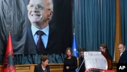 Xhemajlie Demaci, wife of human rights defender Adem Demaci, walks by his coffin in parliament's hall, in Pristina, July 27, 2018.