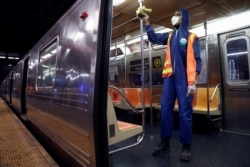 FILE - A worker wipes down surfaces as the MTA Subway closed overnight for cleaning and disinfecting during the outbreak of the coronavirus disease (COVID-19) in the Brooklyn borough of New York City, May 7, 2020.