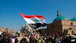 Army soldiers try to prevent anti-government protesters from crossing the al- Shuhada (Martyrs) bridge in central Baghdad, Iraq, Nov. 6, 2019. 