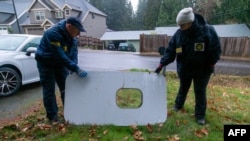 This handout image released by the National Transportation Safety Board (NTSB) shows agents inspecting the door plug from Alaska Airlines Flight 1282 on January 8, 2024 after being found in Portland, Oregon.