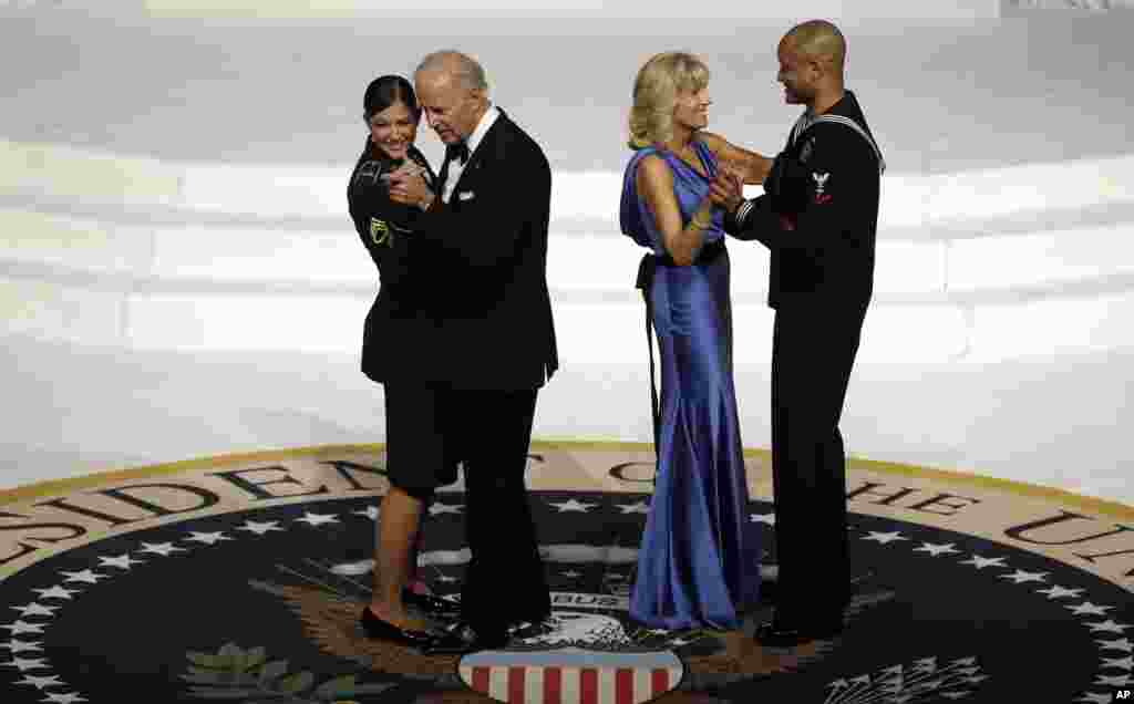 Wakil Presiden Joe Biden berdansa dengan staf Angkatan Darat Sersan Keesha Dentino, sementara istrinya Jill Biden berdansa dengan anggota Angkatan Laut Koptu Patrick Figueroa dalam pesta dansa inaugurasi Komandan Tertinggi Militer (21/1).