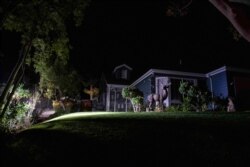 A home sits without power during the Tick Fire, Oct. 24, 2019, in Santa Clarita, Calif. Fast-growing fires throughout California forced tens of thousands of people to evacuate their homes Thursday as dry winds and high heat fed flames.