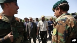 Ali Haidar Gilani son of a former Pakistani prime minister, right, walk with Pakistan Ambassador Abrar Hussain, left, as he arrives at the Ministry of Defense in Kabul, Afghanistan, Wednesday, May, 11, 2016.