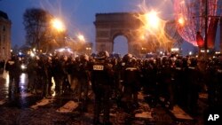 Polisi mengamankan Champs-Elysees, saat berlangsung unjuk rasa memprotes kenaikan biaya hidup di Paris, Perancis, 15 Desember 2018.