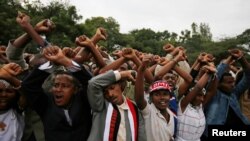 FILE - Demonstrators protest gesture during Irreecha, the thanksgiving festival of the Oromo people, in Bishoftu town, Oromia region, Ethiopia. More than 50 people were killed in the violence. 
