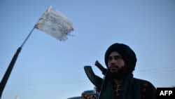 A Taliban fighter stands along a road in Herat on Sept. 19, 2021.
