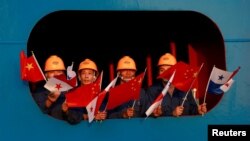 FILE - Sailors wave the China and Panama flags to China's President Xi Jinping at the Cocoli locks in the expanded Panama Canal, in Panama City, Panama, Dec. 3, 2018.