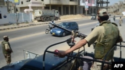 Pakistani paramilitary soldiers stand guard on a street ahead of the upcoming parliamentary elections, in Karachi on May 9, 2013. 