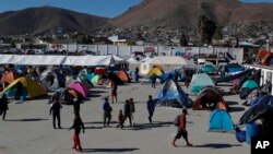 Migrants walk inside a former concert venue serving as a shelter in Tijuana, Mexico, Dec. 3, 2018.