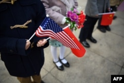 Children hold national flags before the arrival of China's President Xi Jinping and U.S. President Donald Trump during a welcome ceremony at the Great Hall of the People in Beijing, Nov. 9, 2017.