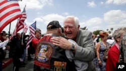 FILE - Former Vietnam POW Orson Swindle, right, gets a hug from Jim Janeway as he arrives to celebrate the 40th reunion for Vietnam POWs at the Richard Nixon Presidential Library & Museum in Yorba Linda, California, May 23, 2013.
