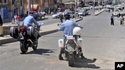 Yemeni policemen attend the scene where an attack took place on a convoy carrying a senior British diplomat in San'a, Yemen, 6 Oct 2010