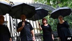 FILE - Members of Hungary's Teachers' Union (PSZ) stand during a protest, at a school year opening event, with black umbrellas over their heads to signify the problems of education, in Budapest, Hungary, Sept. 1, 2022.