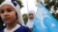 Seorang anak perempuan dari suku Uyghur memegang bendera Turkistan Timur dalam protes menentang penindasan yang dilakukan pemerintah China terhadap suku Uyghur, di Istanbul, Turki, pada 31 Agustus 2022. (Foto: Reuters/Dilara Senkaya)
