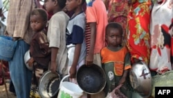 FILE - In this file photo taken on June 16, 2009, internally displaced people line up to receive food aid distributed by World Food Program WFP at one of the camps in Mogadishu. 