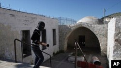 Un jeune au visage masqué marche dans la tombe de Joseph lors des affrontements avec les troupes israéliennes, près de Naplouse, en Cisjordanie, 24 avril 2011. 