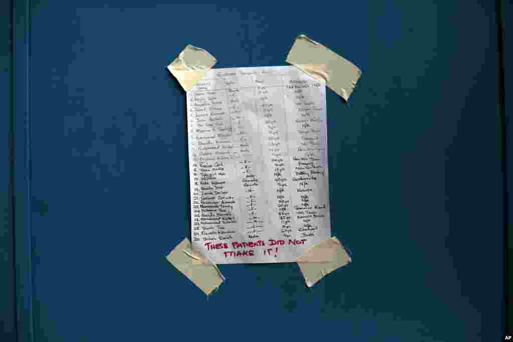 A list showing the names of the deceased for this day is taped on the door of the Island Clinic Ebola treatment unit in Monrovia, Liberia Sept. 30, 2014. 