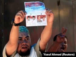 Seorang petugas pemilu memegang surat suara saat penghitungan suara pemilihan presiden di Makassar, Sulawesi Selatan, 9 Juli 2014. (Foto: REUTERS/Yusuf Ahmad)