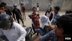 An injured garment worker is helped by his colleagues after clashes broke out during a protest in Phnom Penh, Jan. 3, 2014. 