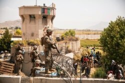 Marines assist with security at an evacuation control checkpoint at Hamid Karzai International Airport in Kabul, Afghanistan, Aug. 20, 2021. (Staff Sgt. Victor Mancilla/U.S. Marine Corps via AP)