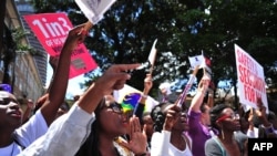 FILE - Women chant slogans during a rally to protest violence against women, in Nairobi, Kenya, Nov. 17, 2014. 