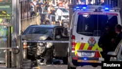 Polisi Australia berdiri di dekat sebuah kendaraan setelah mereka menahan pengemudi kendaraan yang telah menabrak pejalan kaki di persimpangan yang ramai di dekat stasiun kereta Flinders Street di Melbourne tengah, Australia, 21 Desember 2017. (Foto: dok).