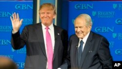 On Feb. 24, 2016, Republican presidential candidate, Donald Trump, accompanied by Rev. Pat Robertson, waves as he arrives for an appearance at Regent University in Virginia Beach, Virginia.