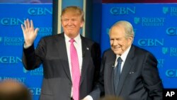 Kandidat presiden saat itu, Donald Trump, ditemani Pendeta Pat Robertson, melambaikan tangan saat tiba di Regent University di Virginia Beach, Virginia (foto: AP Photo/Steve Helber)