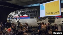 The reconstructed airplane serves as a backdrop during the presentation of the final report into the July 2014 crash of Malaysia Airlines flight MH17, in Gilze Rijen, the Netherlands, October 13, 2015.
