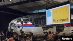 FILE - The reconstructed airplane serves as a backdrop during the presentation of the final report into the July 2014 crash of Malaysia Airlines flight MH17, in Gilze Rijen, the Netherlands, October 13, 2015.