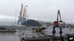 In this July 24, 2016 photo, coal brought from Siberia are be seen awaiting loading onto a ship bound for China in the North Korean special economic zone of Rason.